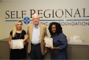 Scholarship recipients Kayla Cleveland (left)and Ebony Clark (right) receive their Scholarship certificates from John Heydel, Founder of the M. John and Drenda Heydel Respiratory Therapy Scholarship.